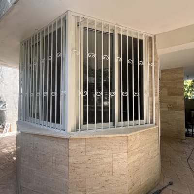 סורגים לבנים על חלונות זכוכית בפינת מבנה