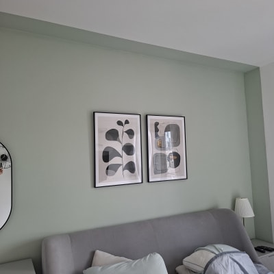 חדר שינה עם מיטה, כריות ותמונות על הקיר