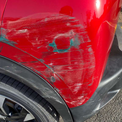 נזקי שריטות ושפשופים על פגוש רכב אדום