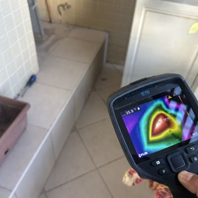 מד חום תרמי על רקע אריחים וכלי עבודה