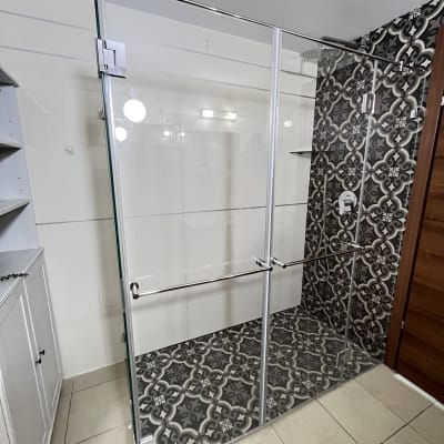 מקלחון זכוכית עם דלתות פתיחה ורצפת אריחים מעוצבים