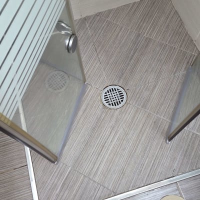 מקלחון עם רצפת אריחים וניקוז