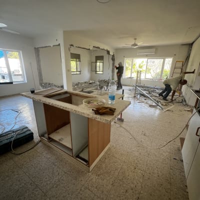 שיפוץ בית עם קירות שבורים וכלי עבודה על הרצפה