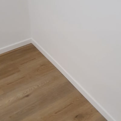 רצפת פרקט עץ בהירה ליד קיר לבן