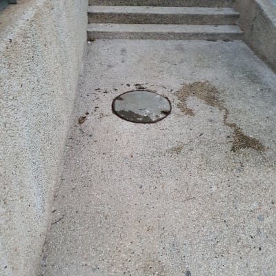 פתח ביוב עגול על מדרכה