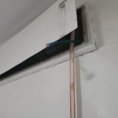 חוטים חשמליים יוצאים מקיר פתוח בשיפוץ