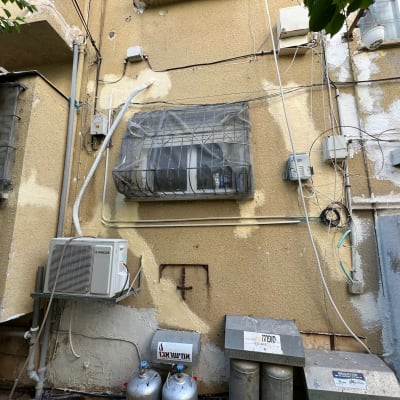 יחידת מזגן חיצונית עם צינורות ואיטום קירות