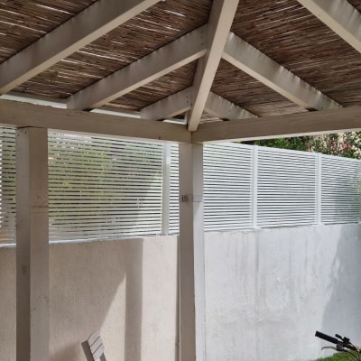 פרגולה מאלומיניום עם גג עץ וגדר לבנה