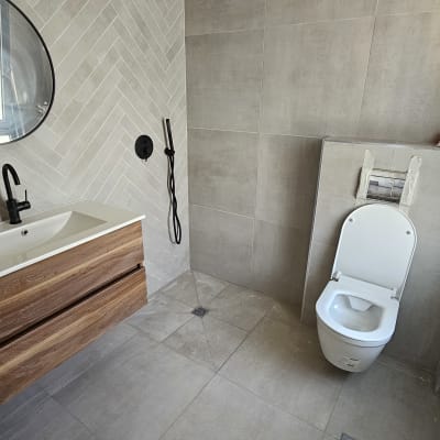 חדר אמבטיה עם אריחים חדשים, כיור ומקלחת