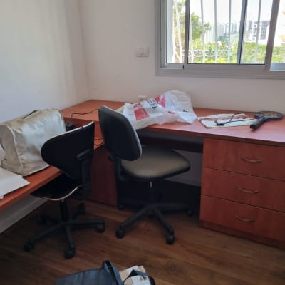 שולחן כתיבה עם כיסאות וחפצים שונים בחדר