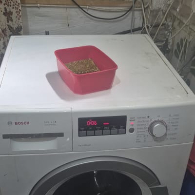 מכונת כביסה עם קערה אדומה על גבי המכסה