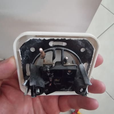שקע חשמלי מפורק ביד חשמלאי