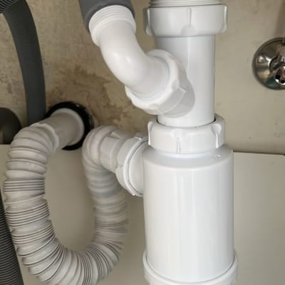 צנרת פלסטיק מתחת לכיור עם חיבורים וגמישות