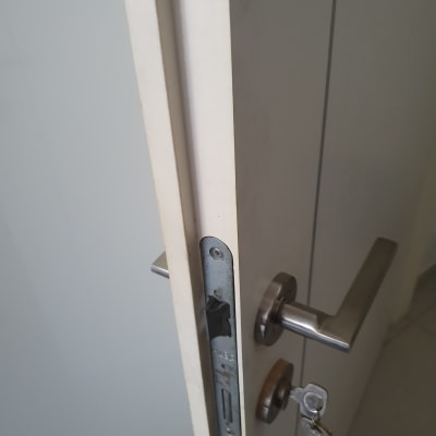 דלת לבנה עם ידית מתכת ומנעול פתוח