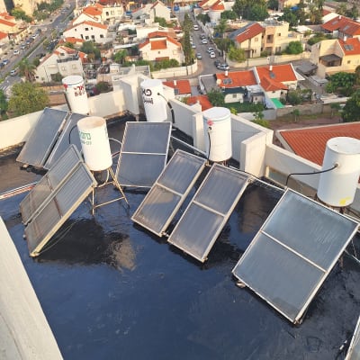 גג אטום בזפת עם דודי שמש וקולטים