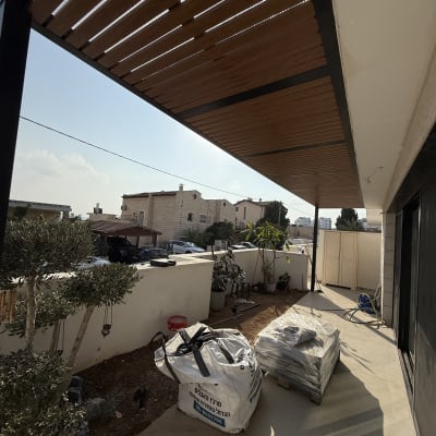 פרגולה מעץ מעל מרפסת עם שקי חומרי בניין