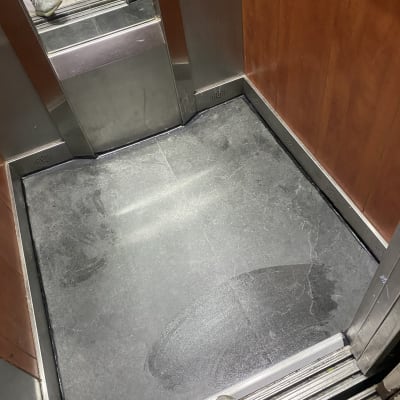 רצפת מעלית עם סימני רטיבות ונעליים