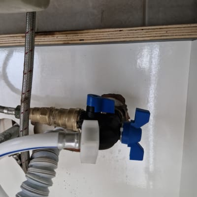 ברז עם ידיות כחולות וצינורות מתכת וגומי