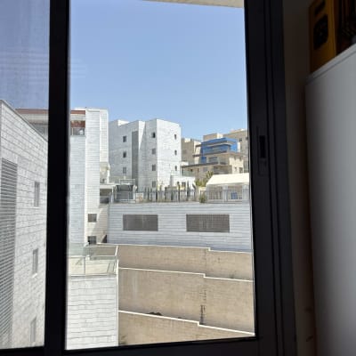 נוף עירוני מבעד לחלון זכוכית עם בניינים מודרניים