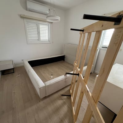 חדר עם מיטה מפורקת ורצפת עץ