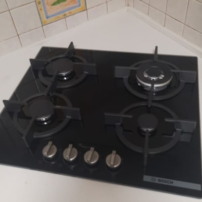 כיריים גז שחורות עם ארבעה מבערים במטבח