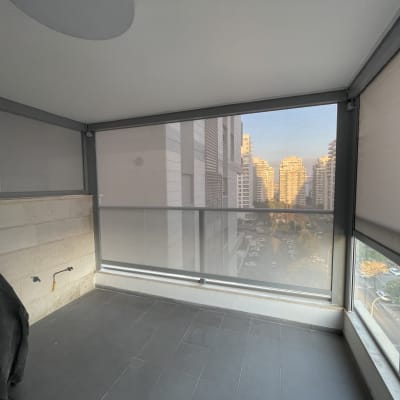 מרפסת עם סוככים נגללים ונוף עירוני