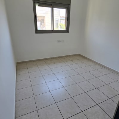 חדר ריק עם קירות לבנים ורצפת אריחים