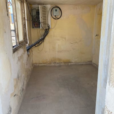 חדר ריק עם קירות מתקלפים ולוח חשמל פתוח