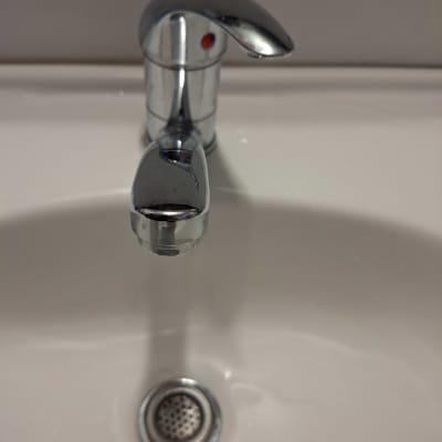 ברז כרום מעל כיור לבן עם ניקוז