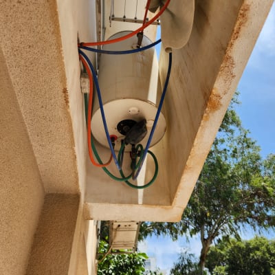 דוד שמש עם צינורות צבעוניים מחובר לקיר