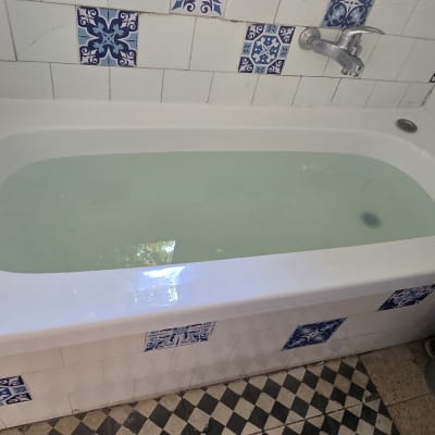 אמבטיה עם אריחים כחולים ולבנים על הקירות