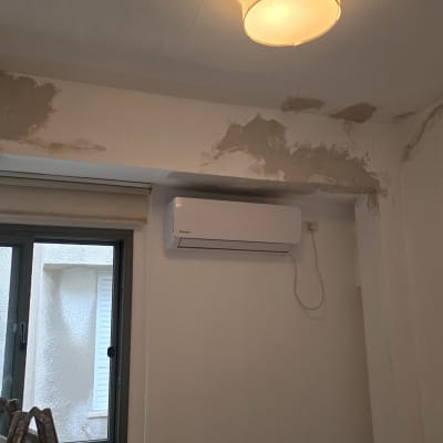 קיר עם תיקוני טיח ליד מזגן