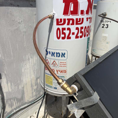 דוד שמש עם צינור ומדבקה אדומה על גג