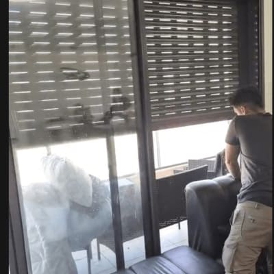 אדם ליד חלון עם תריסים סגורים