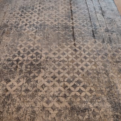 שטיח עם דוגמה גיאומטרית על רצפה ליד חלון