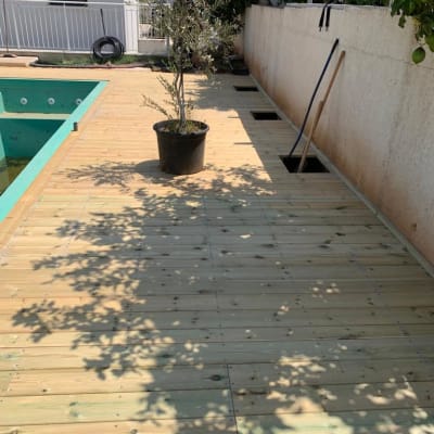 דק עץ עם עציץ וכלי עבודה בגינה