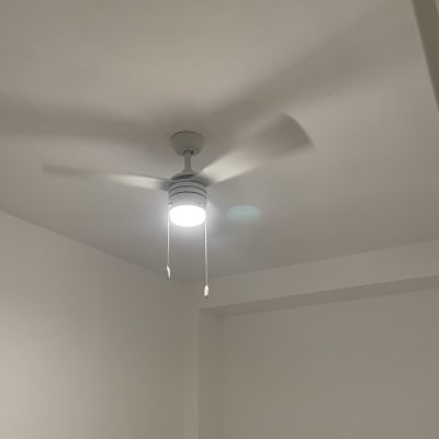 מאוורר תקרה עם תאורה מותקן על תקרה לבנה