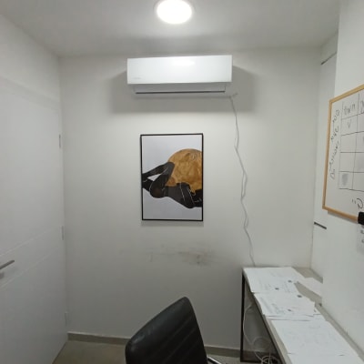 מזגן מותקן על קיר לבן בחדר קטן