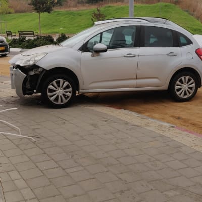 רכב עם פגוש קדמי פגוע על מדרכה
