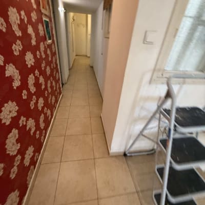 מסדרון עם קיר אדום ומדף מתכת