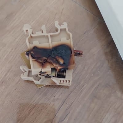 חלק חשמלי שרוף על רצפת עץ