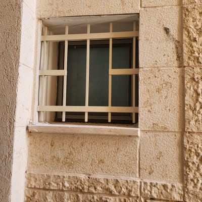 חלון עם סורגים על קיר אבן