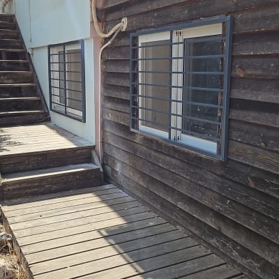 חלונות עם מסגרות מתכת על קיר עץ חום