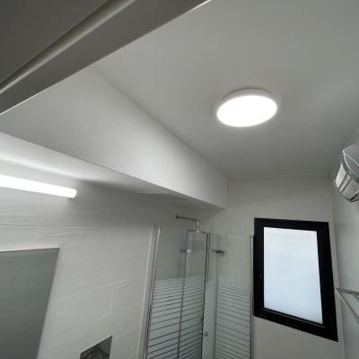 תאורה ותקרה בחדר אמבטיה עם חלון ומקלחת