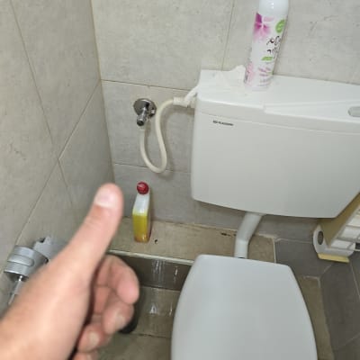 אסלה עם בקבוק חומר ניקוי ומיכל מים