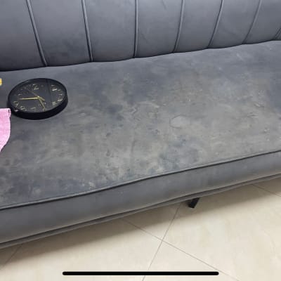 ספה מלוכלכת עם שעון ומטלית ורודה