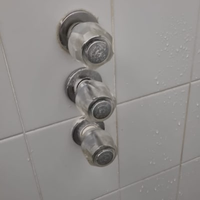 ברזים מותקנים על קיר אריחים בחדר אמבטיה