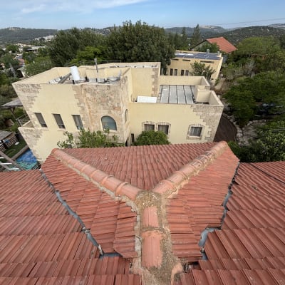 גג רעפים אדום עם חיבור מרכזי ותיקונים