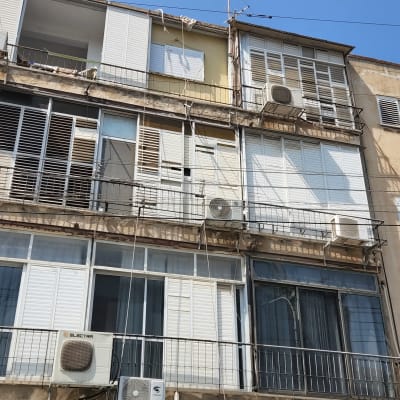 בניין עם מזגנים וחלונות תריסים