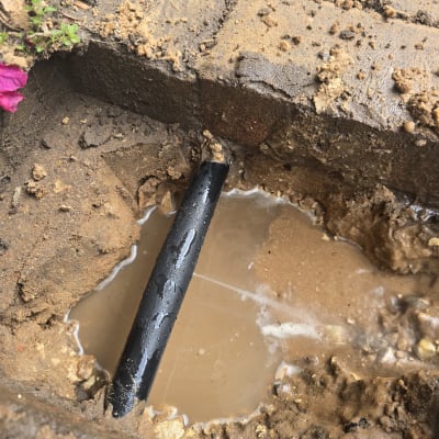 צינור מים שבור באדמה רטובה עם בוץ